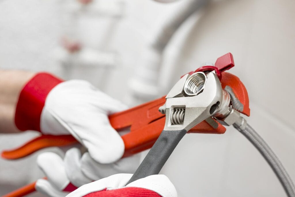 Plumber holding pipe wrenches for an emergency repair in Watsonville