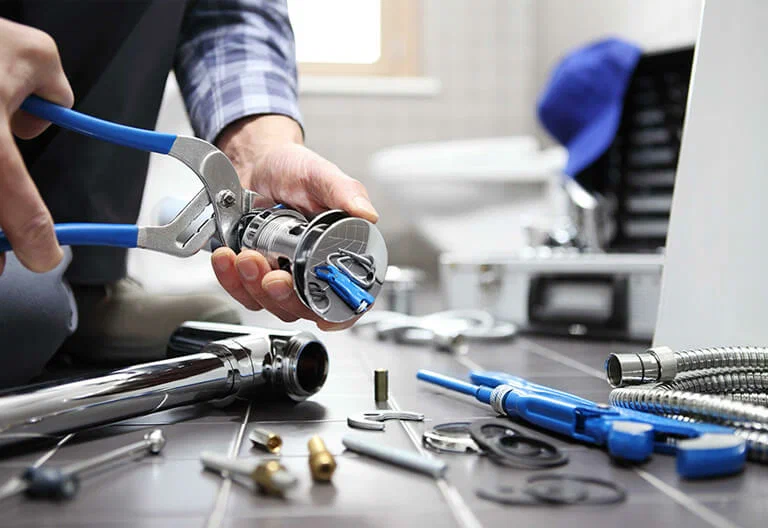 Technician repairing a plumbing fixture with professional tools in Watsonville