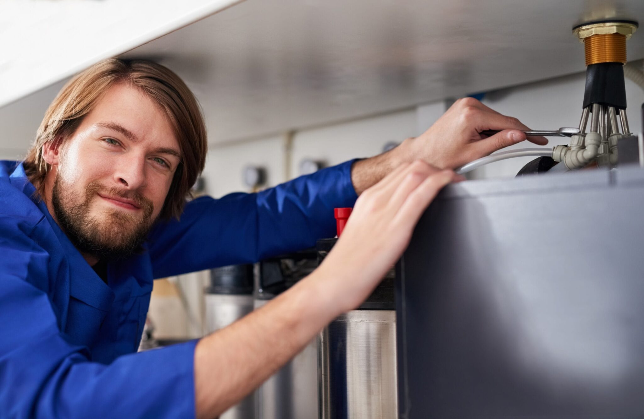Technician servicing a residential water heater tank in Watsonville
